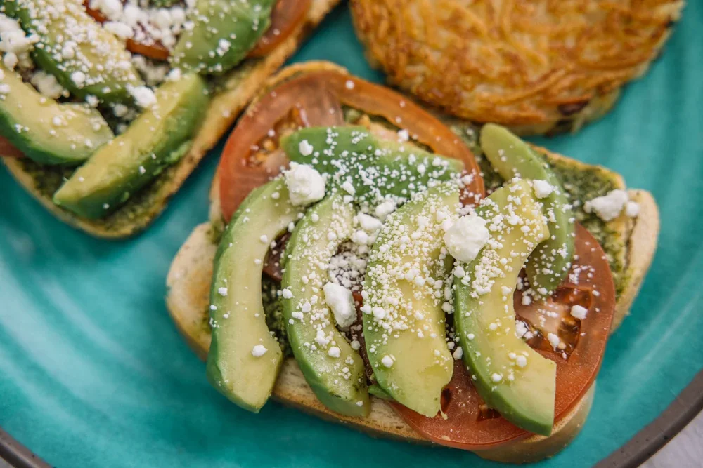 Avocado toast with tomato, goat cheese and pesto